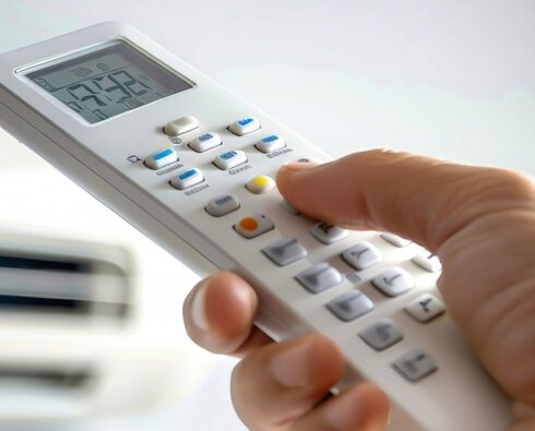 Hand holding smart control for HVAC